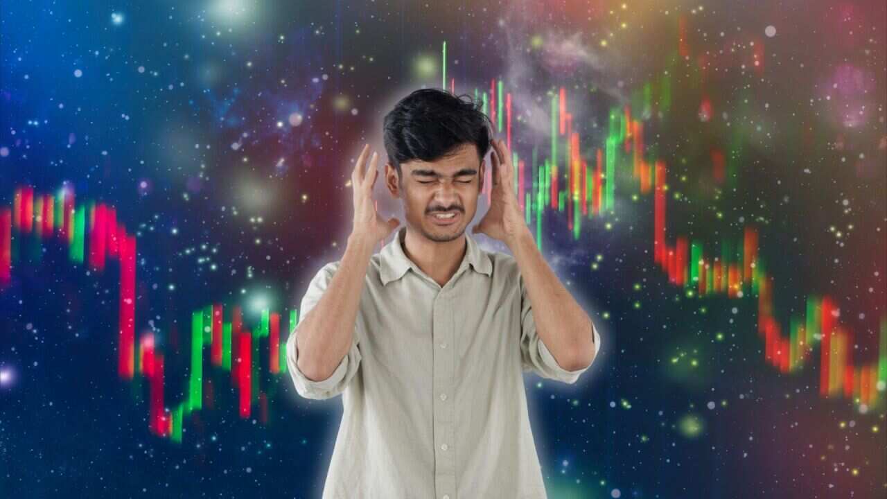 Image of a stressed young man squinting his eyes and putting his hands near his forehead on a background of a finance background.
