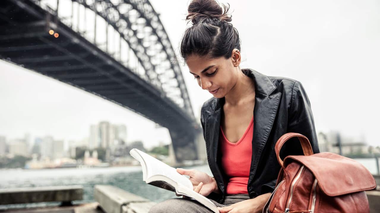Indian woman in the city of Sydney reading a book